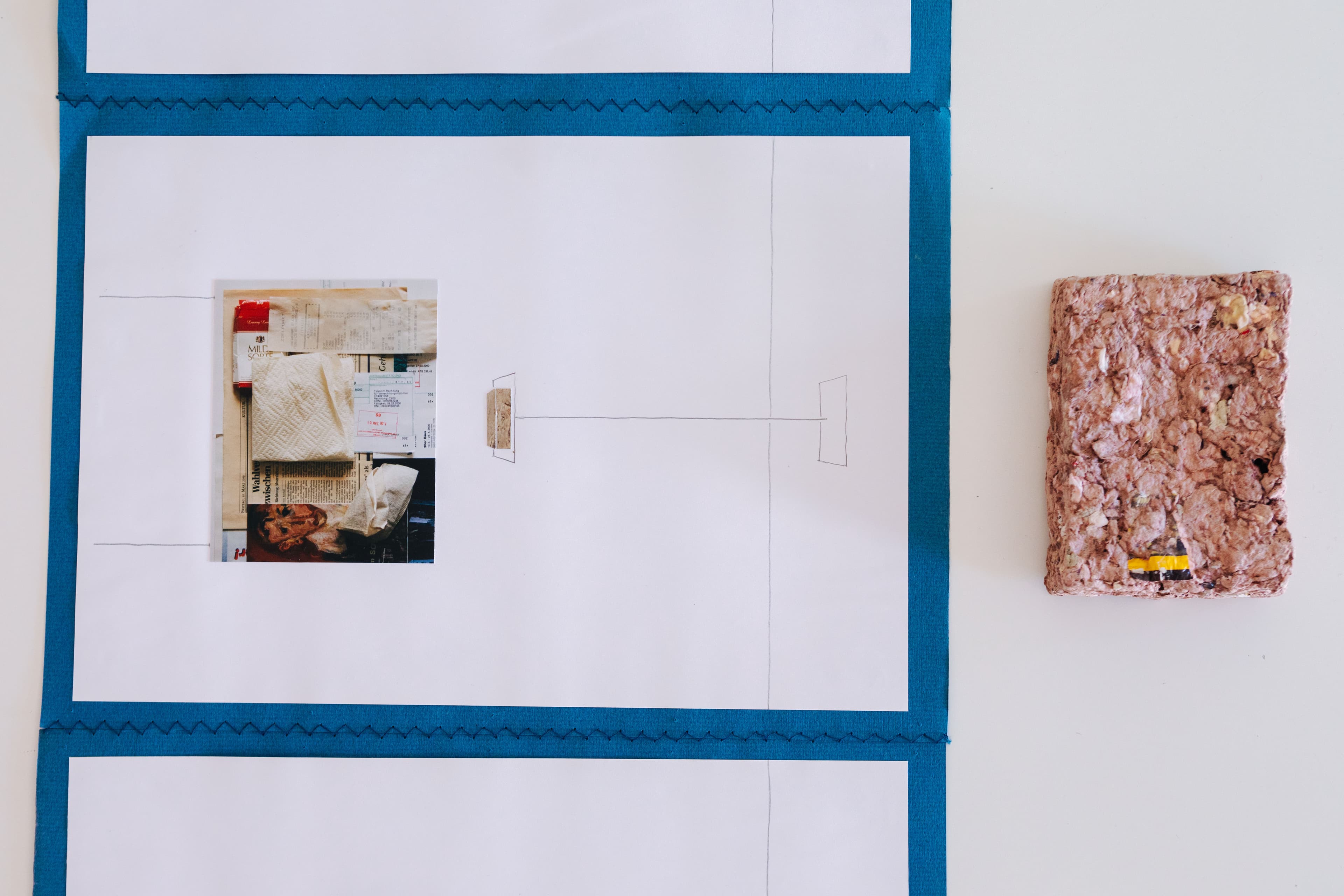 Leporello mit Collagen neben einem Brikett aus geschöpftem Altpapier